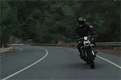 Gemini Omni - Dramatic low-angle shot of a motorcycle rider on a mountain road at dusk.